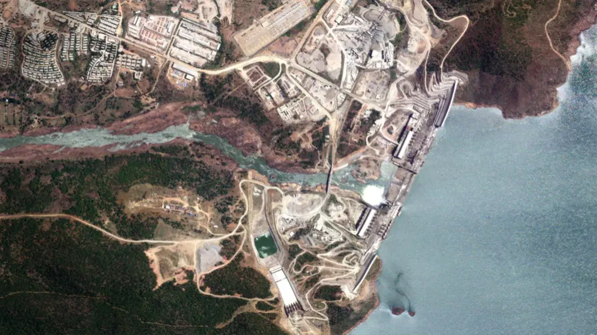 Satellogic true color satellite image of a dam and reservoir with surrounding roads, buildings, and vegetation