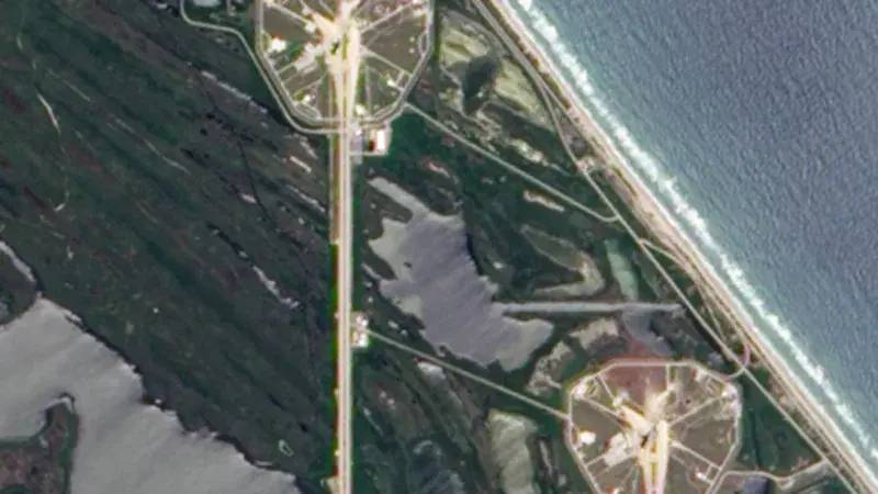 Satellite view of the Cape Canaveral coastline, where launch complexes and causeways sit between wetlands and the Atlantic shoreline