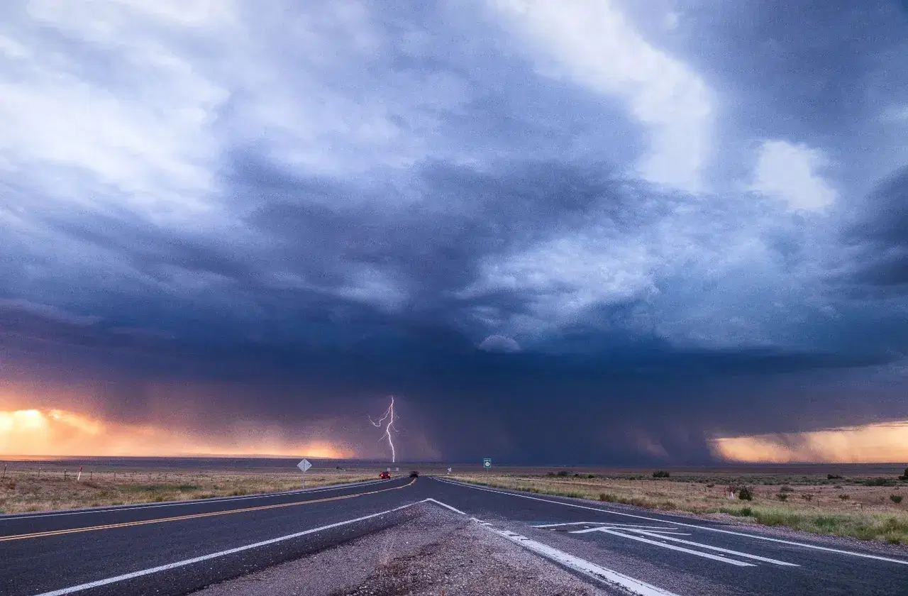 A powerful thunderstorm with lightning approaches on the horizon at sunset over a desert highway near Belen, New Mexico, Jul 27, 2019. Credit: Raychel Sanner/Pexels
